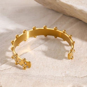 Macro detail of 18k gold plated stainless steel cuff bracelet with rhinestones and beads
