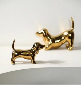 Close-up of modern gold dachshund sculptures with polished metallic finish for home decor