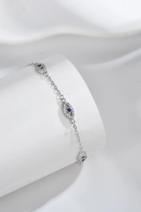 Macro shot of silver Evil Eye bracelet with blue crystal charms and white zircon pavé