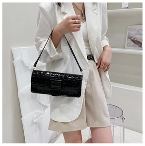 Chic black croc-embossed shoulder bag with rectangular clasp shown on a model