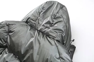 Detailed close-up of glossy dark grey puffer jacket showing hood texture and quilting