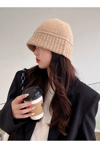 Close-up of khaki chunky knit bucket hat showing warm wool texture and woven pattern