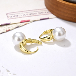 Elegant gold hoop earrings with large white pearls in a minimalist French style