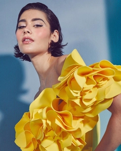 Macro detail of vibrant yellow one-shoulder swimsuit with layered 3D floral embellishment