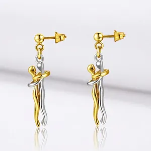 Macro detail of bicolored hug earrings featuring polished gold and silver figures