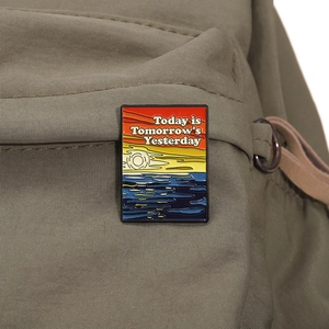 Detail of artistic metal badge with ocean sunset on a beige backpack