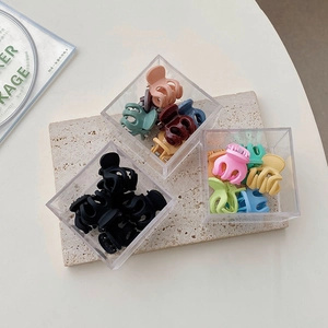 Vue macro de mini pinces à cheveux colorées dans des boîtes de rangement organisées