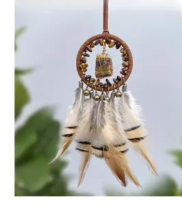 Detail of bohemian dreamcatcher car charm with tiger eye stone and natural feathers