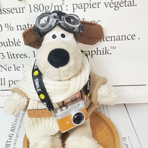 Close-up of Gromit plush toy featuring aviator goggles and a vintage orange camera toy