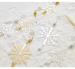 Detailed close-up of gold and silver cutout Christmas ornaments with crystal beads