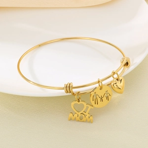 Detailed close-up of a gold adjustable bracelet with MOM letters and family charms