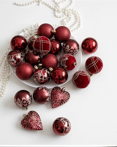 Detail of red Christmas baubles with reindeer and snowflake patterns on a white plate