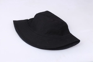 Detailed close-up of the black cotton fabric texture on a flat-lay bucket hat