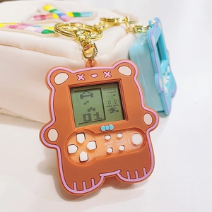 Close-up of brown bear mini game console keychain featuring Tetris screen and white buttons