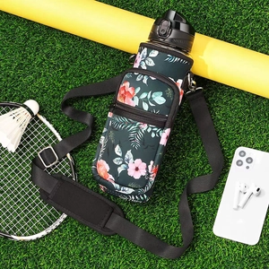 Detail view of floral SBR water bottle sleeve with adjustable strap on grass background
