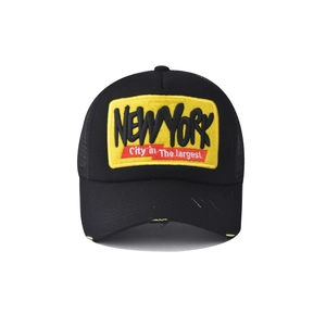 Detailed shot of 3D embroidered NEW YORK patch on a vintage black trucker mesh hat