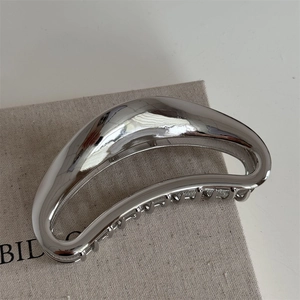 Detailed top view of large silver alloy moon crescent hair claw with polished metallic finish