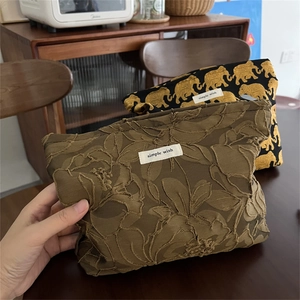 Detail of vintage elephant jacquard makeup bag with leaf texture and textile label