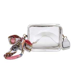 Clear PVC crossbody bag detail showing white leather trim and colorful silk scarf accent