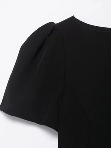 Detail shot of the pleated puff sleeve design on a black off-shoulder mini dress