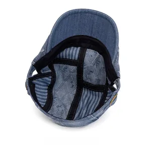 Internal view of denim newsboy cap showing quilted lining and adjustable metal buckle