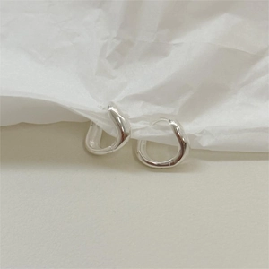 Gros plan détaillé de boucles d'oreilles créoles organiques en argent sterling 925 poli