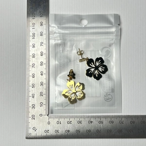 Detailed size measurement of hollow flower earrings showing 22mm diameter on a metal ruler