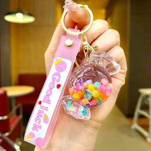 Close-up of pink acrylic candy-shaped keychain with colorful sequins and a metal ring
