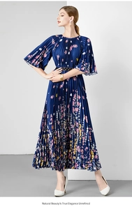 Detail van de geplooide maxi-jurk met bloemenprint en metalen gesp in de taille