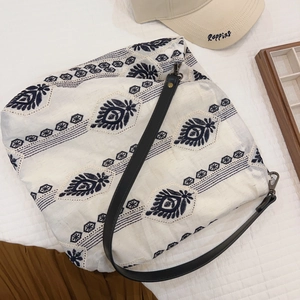 Detail of bohemian floral embroidery on white cotton linen shoulder tote bag
