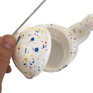 Detail shot of white splatter canister with lid removed showing interior storage space