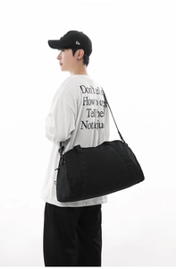 Black large capacity sports gym bag and travel duffel shown on a model's shoulder