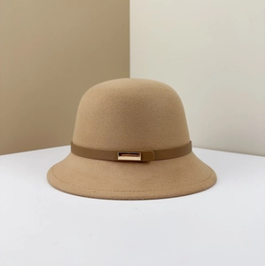 Detail of camel wool felt bucket hat featuring dark brown leather strap and gold buckle