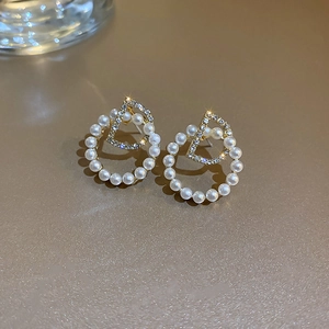 Vue macro de boucles d'oreilles dorées lettre D avec perles et strass brillants de luxe