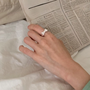 Close-up of 925 sterling silver bow ring on hand with vintage newspaper background