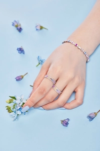Macro shot of S925 silver rainbow gemstone rings and bracelet set on a blue background