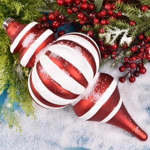 Red and white spiral finial Christmas ornament with snow texture on pine branches