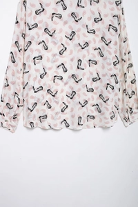 Detailed macro view of retro paisley and boot prints on white long-sleeved shirt fabric