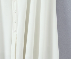 Close-up of white chiffon dress showing fabric texture and vertical row of buttons