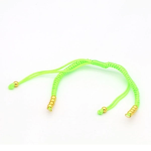 Detail showing neon green braided cord bracelet with adjustable gold beads and closures