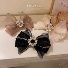 Detail view of woven flower hair claws with velvet and organza layers and rhinestones