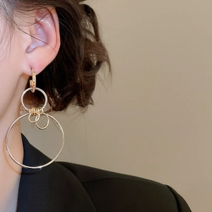 Close-up of stylish large geometric hollow circular drop earrings on model side view