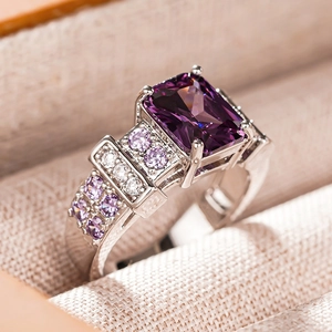 Macro shot of a purple rectangle gemstone ring with pavé diamonds in a jewelry box