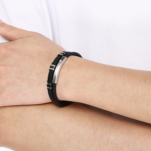 Detail of man wearing black woven leather double-layer bracelet with curved steel plate