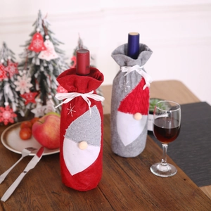 Detail of red and grey gnome wine bottle covers on a festive wooden Christmas table