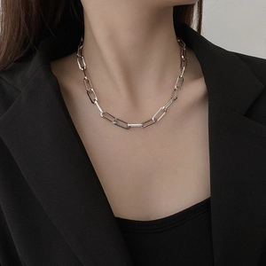 Minimalist silver chunky paperclip chain necklace styled on model with a black suit jacket