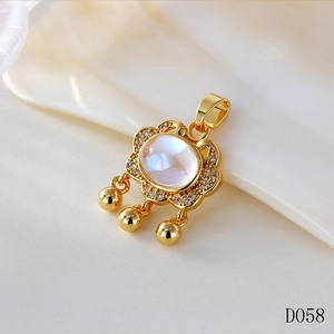 Macro shot of gold Ruyi lock pendant with iridescent moonstone and dangling small bells