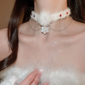 Détail du ras-du-cou d'hiver avec fourrure blanche, perles rouges et pendentif fleur