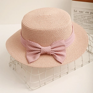 Pink woven straw boater hat with striped ribbon bow decoration for summer beach travel