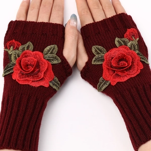 Close-up of wine red knitted fingerless gloves featuring elegant rose embroidery detail